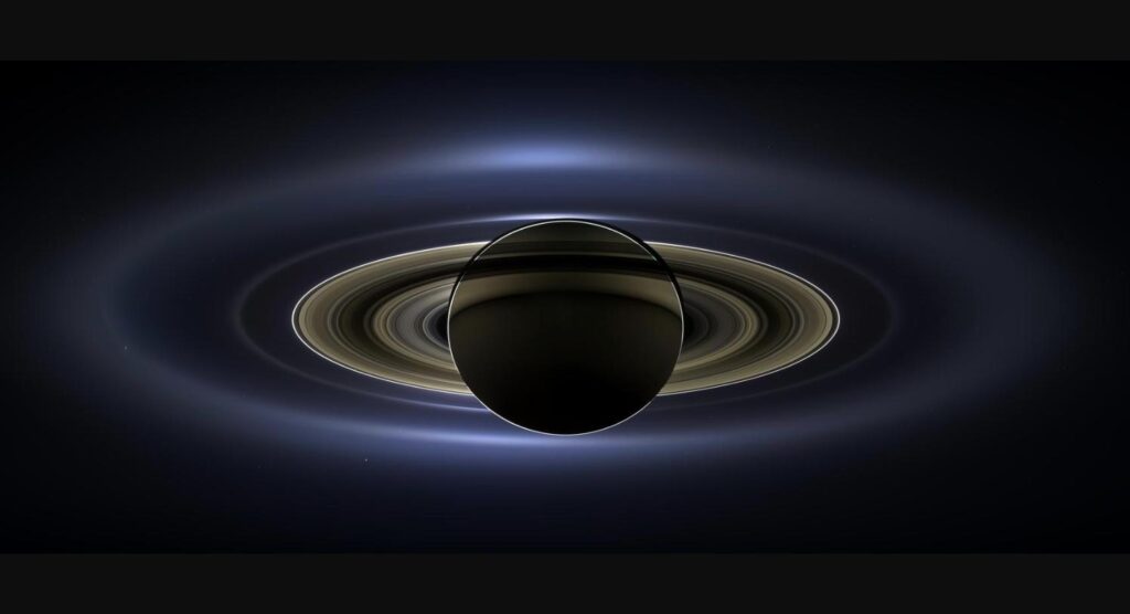 Saturn and its glorious rings, with tiny Earth visible